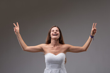 Elated jubilant woman cheering and giving a V-sign