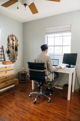Anonymous woman with short hair working at desk in home office 