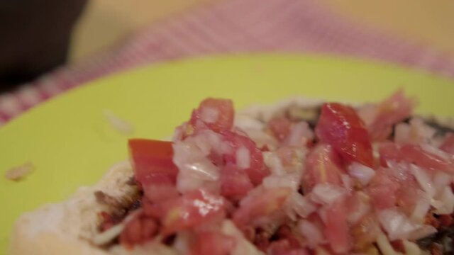 Traditional Mexican molletes on a plate above white and red checkered napkin