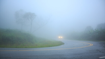 Foggy road on the mountain with a car in background