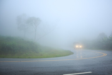 Small truck driving on the foggy road, This is a danger road on the mountain at northern Thailand
