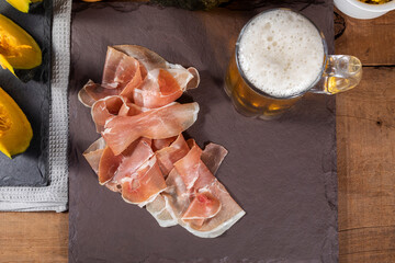 Italian prosciutto crudo or jamon with pumpkin mashed. Raw ham on wood