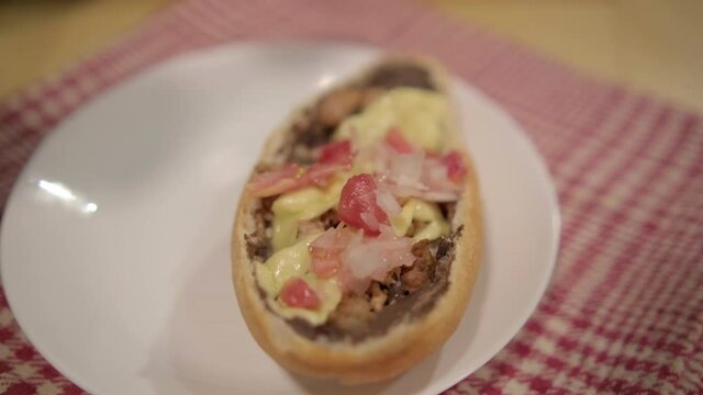 Traditional Mexican mollete on a plate above white and red checkered napkin