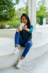 MUJER JOVEN HISPANA TURISTA HACIENDO SELFIE CON TELEFONO INTELIGENTE CELULAR