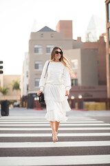 Fototapeta premium Adult happy woman crossing the street in the city.