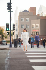 Adult happy woman crossing the street in the city.