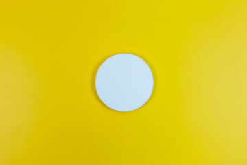 Blank white circle isolated on yellow background with shadow