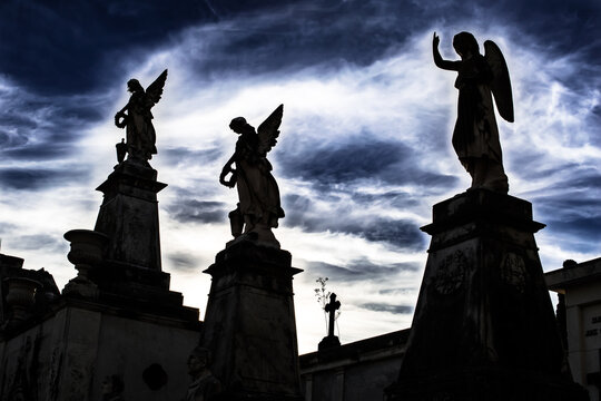 Siluetas de estatuas de ángeles en cementerio un día de tormenta