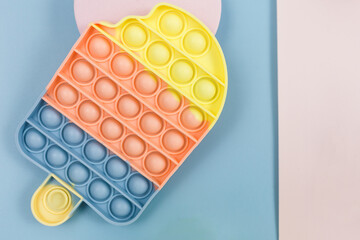 Popular silicone pastel anti-stress pop it toys and geometric shapes for a child on blue pink background. Trendy Sensory Fidget Toy. Funny Bubble suitable for relieving stress for adults