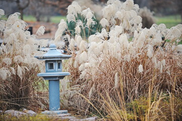 Japanese-style stone lantern among various plants in the botanical garden © Vladimir