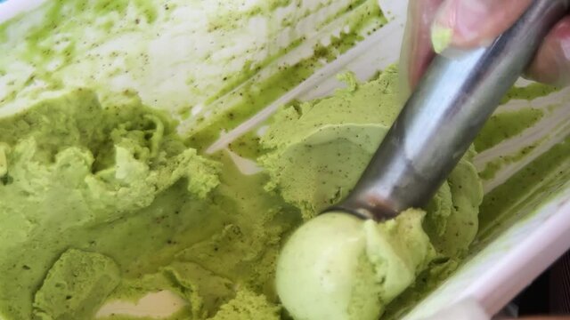 Ice cream maker shapes a ball of pistachio ice cream. High quality 4k footage
