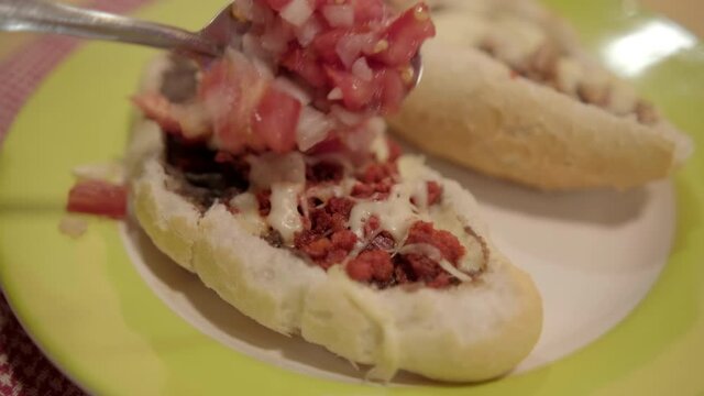 Traditional Mexican mollete on a plate above white and red checkered napkin