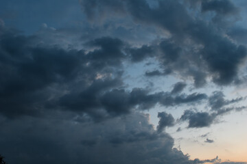 Fototapeta na wymiar Evening time dark thunderstorm or rainy clouds and blue and orange sky