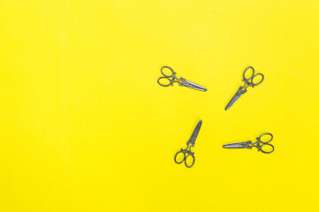 small ornament scissors on yellow background. space for text