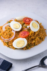 rice noodle dish, also known as string hoppers biryani with boiled eggs, tomatoes, onions and curry leaves, served sri lankan and south indian dish closeup view