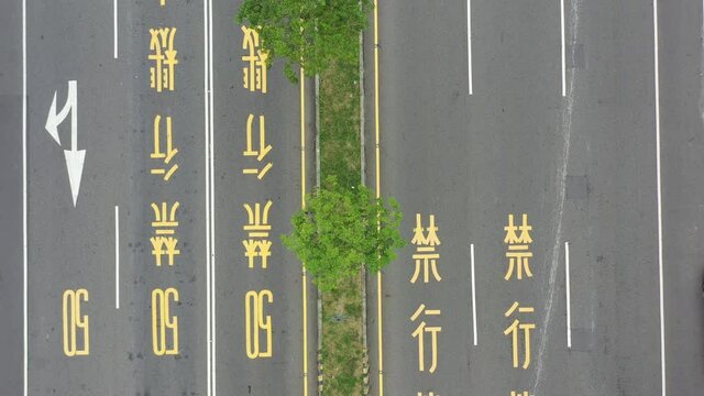 Aerial Drone Footage of Zoom Out Bird Eye View of Asphalt Road and Traffic in Taiwan with Chinese words signage of speed limit 50 and motorcycle is prohibited painted on the road.