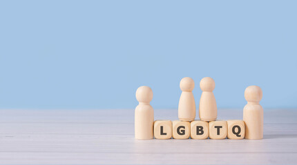 LGBT word on wooden blocks and group of wooden figure on blue background as represent human relationship in cousin.Concept rainbow love.Human rights and tolerance