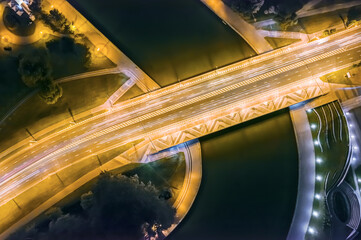 modern city bridge over a river illuminated at night. aerial photo, top view.