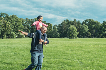 Father playing with his cute little daughter on the field. Concept of friendly family. Great family vacation.