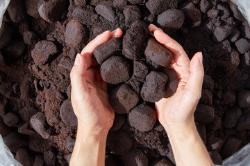 Unused coffee grounds with male hand.