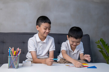 Portrait of asian children playing colorful blocks, Learning by playing education home school concept, kids playing with puzzle doing tangram, education concept, Two kids playing with blocks games
