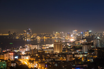 Obraz premium The bay and skyscrapers in twilight time and midnight time in Pattaya, Thailand. Pattaya city is famous for sea sport and night life entertainment.