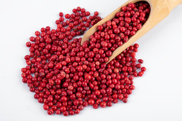 Wooden scoop with different pepper grains on white background, dried pink peppers isolated on white, dried pink peppercorns isolated on white