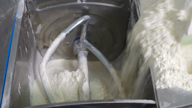 Preparing dough with professional mixer. Electric Hook Machine. Mixing Flour, Water, Eggs. Homemade healthy food. chef pouring, adding flour into mixer bowl. Pastry work. kneading dough for bread or