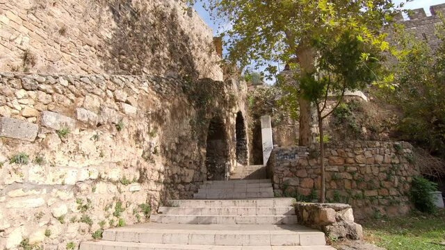 Wide dolly shot of the ancient stone walls surrounding the city of Antalya in Turkey, bright summers day.