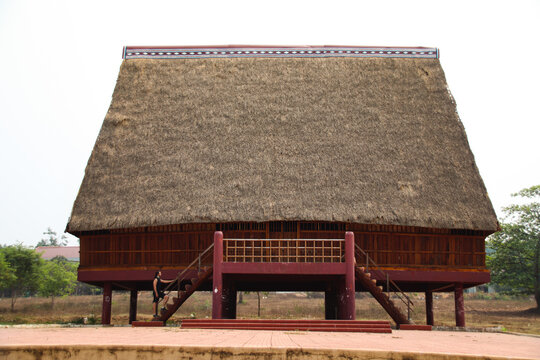 A tourist exploring a traditional architecture of a Bahnar ethnic stilt house or Rong House in Pleiku countryside, Vietnam