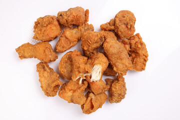Light battered deep fried chicken variety mix pieces pile flaky meat on white background healthy fry