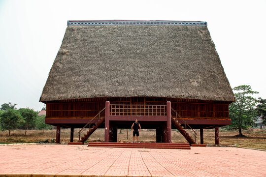A tourist exploring a traditional architecture of a Bahnar ethnic stilt house or Rong House in Pleiku countryside, Vietnam