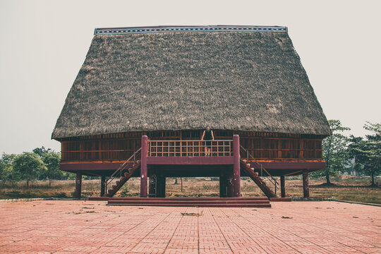 A tourist exploring a traditional architecture of a Bahnar ethnic stilt house or Rong House in Pleiku countryside, Vietnam