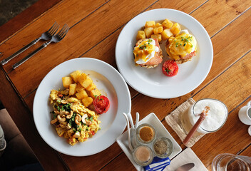 Scrambled and eggs benedict served with grilled potatoes and coffee