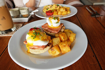 Scrambled and eggs benedict served with grilled potatoes and coffee