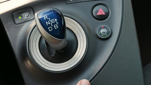 Turin, Italy, June 2021. Close up shot of the LPG petrol changeover button of a converted Toyota Pirus with BRC system. The finger presses the button: the red LED indicates petrol power.