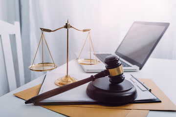 Justice and law concept.Male judge in a courtroom with the gavel, working with, computer and docking keyboard, eyeglasses, on table in morning light