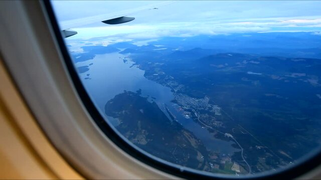 View from airplane window on fields in wing with top view of Vancouver, Canada