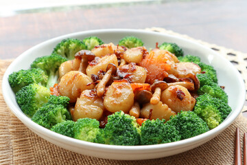 Stir fried Scallops with mushroom in  XO sauce of a white plate garnished with broccoli - close up...