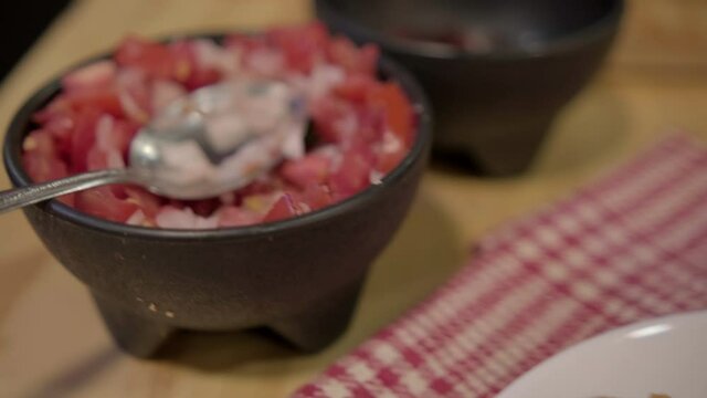 Traditional Mexican mollete and bowl of pico de gallo above checkered napkin