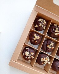 Chocolate candies, in a paper box on the table.