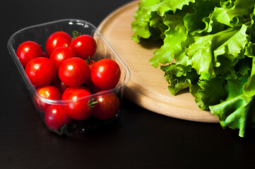 green lettuce and cherry tomatoes on a dark background. High quality photo