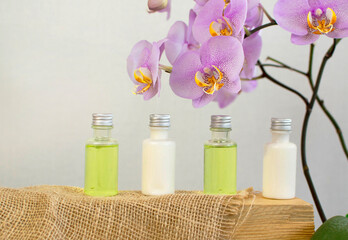Body care product in shower and shampoo on white background, with pink orchid. The concept of daily skin care. Plastic bottle of shampoo with floral fragrance. Simple example of shampoo