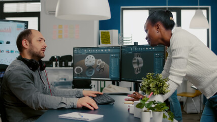 Diverse team of engineer architects working on modern cad program developing construction metalic components. Industrial designer studying prototype idea on pc showing digital software with gears