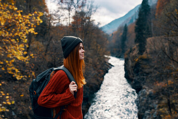 sunny tourist near river mountains autumn forest landscape