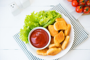 Chicken nuggets with sauce and herbs in a plate