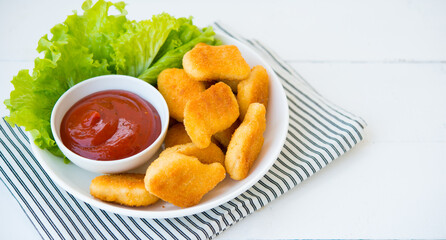Chicken nuggets with sauce and herbs in a plate, selective focus