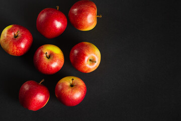 Red ripe apples on a black background.
