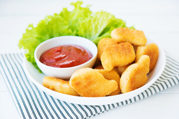 Chicken nuggets with sauce and herbs in a plate, selective focus