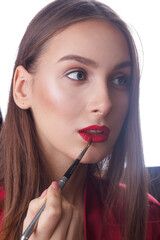 young beautiful woman applies red lipstick